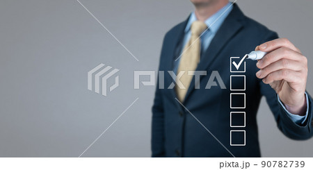 Businessman Making Right Decision. Blank checklist on the whiteboard. Checklist concept, Businessman checking mark on the check boxes. Hand choosing one of many options. banner grey background Businessman Making Right Decision. Blank checklist on the whiteboard. Checklist concept, Businessman checking mark on the check boxes. Hand choosing one of many options. banner grey background 90782739