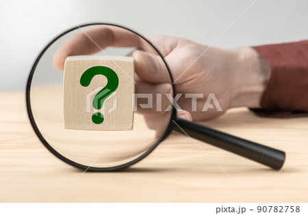 Man hand holding question mark in front of magnifying glass. Search for an answer to question. Research, searching or investigating something. search for solution to problem Man hand holding question mark in front of magnifying glass. Search for an answer to question. Research, searching or investigating something. search for solution to problem 90782758