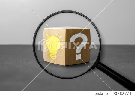 Magnifying glass with light bulb icon and question mark symbol. Concept creative idea and innovation. Magnifying glass with question mark and lightbulb in focus on wooden cube. Magnifying glass with light bulb icon and question mark symbol. Concept creative idea and innovation. Magnifying glass with question mark and lightbulb in focus on wooden cube. 90782771