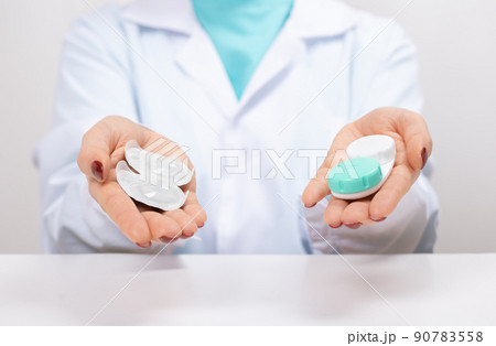 Doctor Ophthalmologist holding in hands one-day contact lenses and reusable contact lenses. choosing between types of contact lenses . myopia and eyesight problem concept 90783558