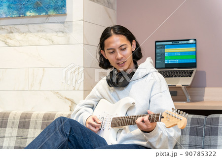 白いエレキギターを弾く若い男性 90785322
