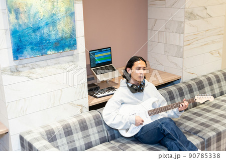 白いエレキギターを弾く若い男性 白いエレキギターを弾く若い男性 90785338