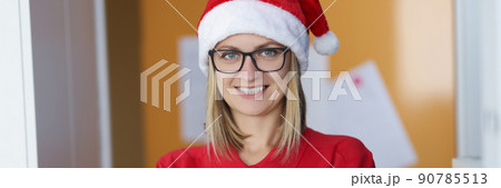 Happy blonde lady courier in red shirt and santa claus hat 90785513