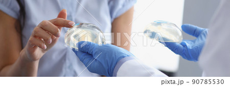 Woman client touch silicone breast implant from doctors hand 90785530