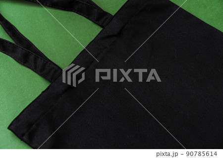 Textile shopping bag on green background flat lay 90785614