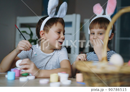 Cute little boys colouring eggs for easter 90786515