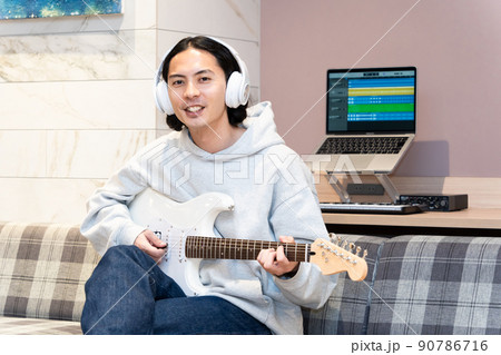 白いエレキギターを弾く若い男性 90786716