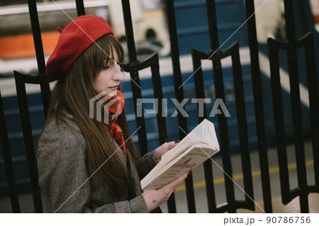 Beautiful Caucasian woman wearing coat, beret, scarf sitting alone on Saint Petersburg metro station reading a book. Image with selective focus and noise effect Beautiful Caucasian woman wearing coat, beret, scarf sitting alone on Saint Petersburg metro station reading a book. Image with selective focus and noise effect 90786756