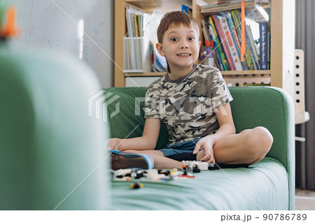 Little caucasian boy constructing a car with plastick blocks 90786789