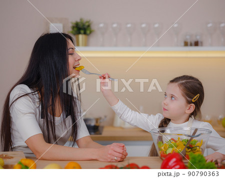 Happy mother and daughter enjoy prepare freshly salad together in kitchen. diet and Health concept. 90790363