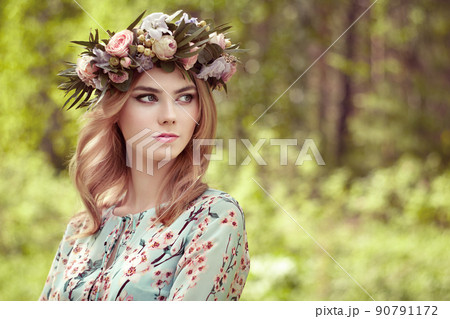 Beautiful blonde woman with flower wreath on her head Beautiful blonde woman with flower wreath on her head 90791172