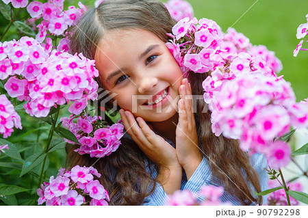 Adorable little girl in pink flowers phlox Adorable little girl in pink flowers phlox 90792298