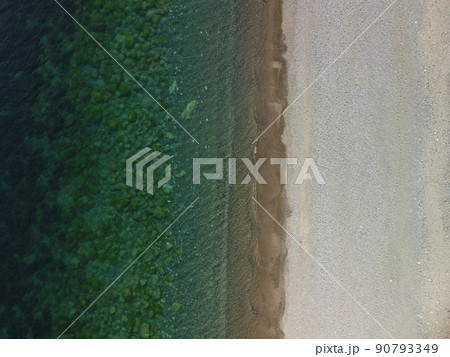 Aerial view on calm azure sea and volcanic rocky shores. Small waves on water surface in motion blur. Nature summer ocean sea beach background. Nobody. Holiday, vacation and travel concept Aerial view on calm azure sea and volcanic rocky shores. Small waves on water surface in motion blur. Nature summer ocean sea beach background. Nobody. Holiday, vacation and travel concept 90793349