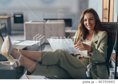 Woman working at home with her feet up on her desk 90793665