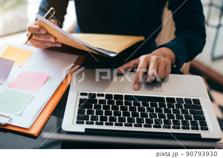 Business man working at office with documents and laptop on his desk, financial adviser analyzing data. Business man working at office with documents and laptop on his desk, financial adviser analyzing data. 90793930