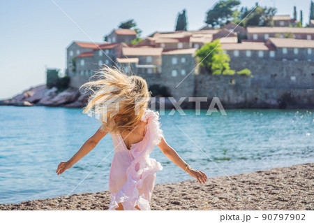 Woman tourist on background of beautiful view of the island of St. Stephen, Sveti Stefan on the Budva Riviera, Budva, Montenegro. Travel to Montenegro concept 90797902