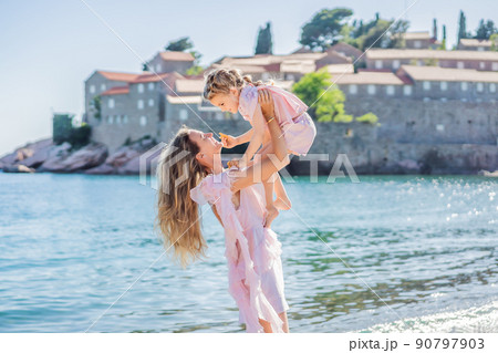 Mother and daughter tourists on background of beautiful view St. Stephen island, Sveti Stefan on the Budva Riviera, Budva, Montenegro. Travel to Montenegro concept 90797903