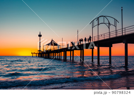 Iconic Brighton jetty with people silhouettes at sunset Iconic Brighton jetty with people silhouettes at sunset 90798324