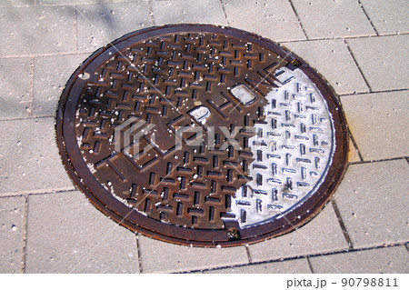 An old oxidized telephone manhole on a public walkaway An old oxidized telephone manhole on a public walkaway 90798811