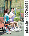 テニスコートのベンチで休憩する女性 90798954