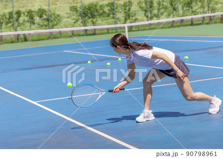 テニスでライン際のボールに追いつく女性 90798961
