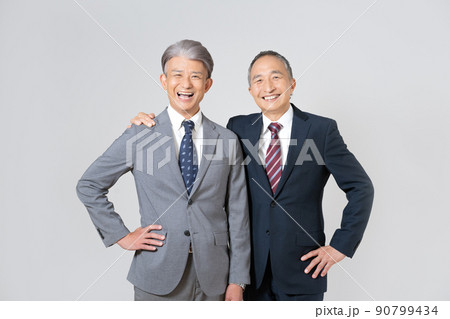 スーツを着て肩を組んで腰に手を当てるシニア男性2人のポートレート 90799434