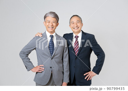 スーツを着て肩を組んで腰に手を当てるシニア男性2人のポートレート 90799435
