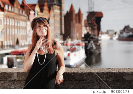 Flapper girl woman in1920s style standing on the street 90800173
