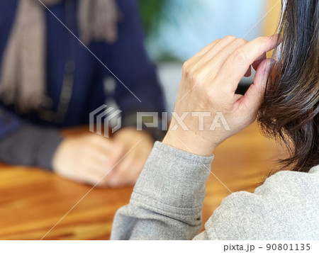 女性の正面で手を髪にやる女性 90801135