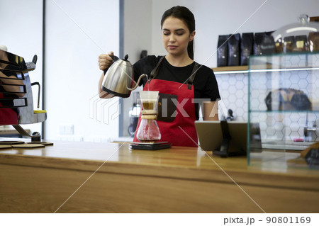 Professional woman barista in apron enjoying making hot coffee order standing at bar 90801169