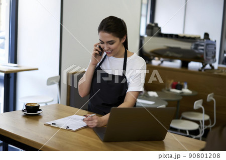 Beautiful woman waitress filling application form checking commercial products Beautiful woman waitress filling application form checking commercial products 90801208