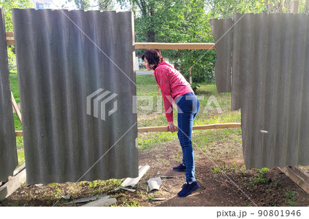 A woman climbs through a fence into a restricted area 90801946