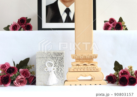 遺影の前に置かれた骨壷と白木位牌。葬儀祭壇のイメージ2 遺影の前に置かれた骨壷と白木位牌。葬儀祭壇のイメージ2 90803157