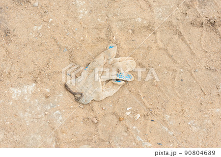 A thrown or forgotten construction glove and tractor tire marks. A thrown or forgotten construction glove and tractor tire marks. 90804689