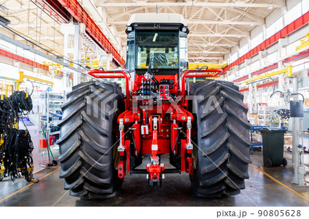 Assembly workshop at big industrial plant. Tractor assembling Assembly workshop at big industrial plant. Tractor assembling 90805628