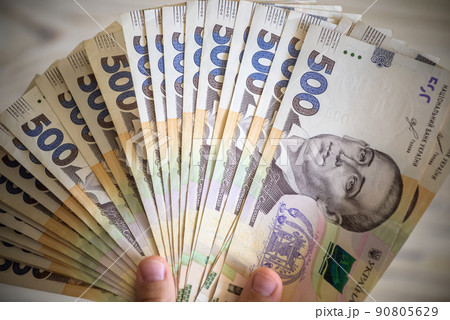 Money of Ukraine. Stack of ukrainian hryvnia banknotes in hands on wooden table. Hryvnia 1000 uah Money of Ukraine. Stack of ukrainian hryvnia banknotes in hands on wooden table. Hryvnia 1000 uah 90805629