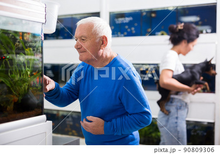 Positive mature man chooses aquarium fish in pet shop Positive mature man chooses aquarium fish in pet shop 90809306