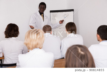 African American man speaking to physicians in conference room African American man speaking to physicians in conference room 90814855