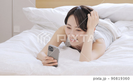 女性　ライフスタイル　ベッド　スマホ 90819360