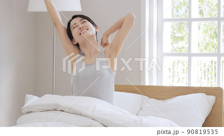 朝　目覚め　女性　ベッド 90819535