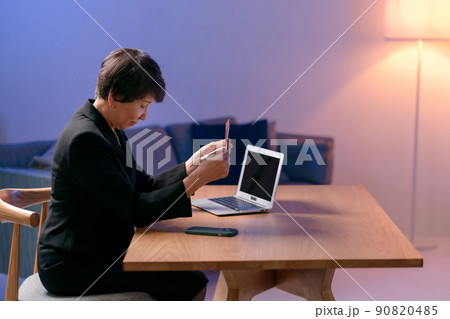 喪服を着て通帳を見る女性　 90820485