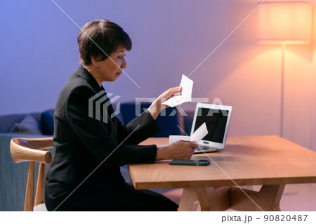 喪服を着て通帳を見る女性　 90820487