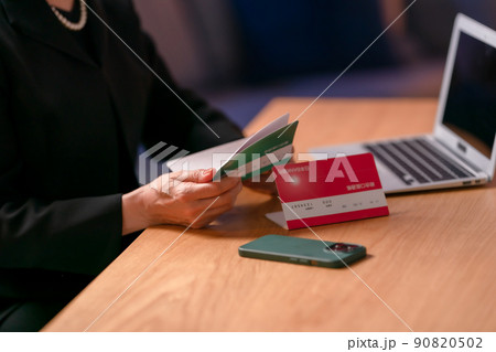 喪服を着て通帳を見る女性　 90820502