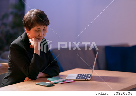 喪服を着て通帳を見る女性　 90820506