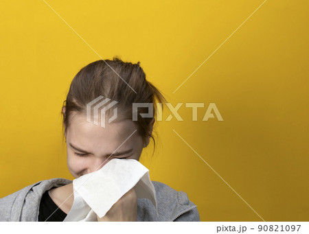 Crying lady wiping tears away tears with tissue paper on yellow background 90821097