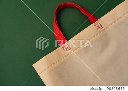 Textile shopping bag on green background flat lay Textile shopping bag on green background flat lay 90823636