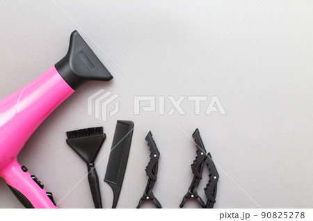 various hairdressing tools like hair dryer, comb on a gray background. beauty salon concept 90825278