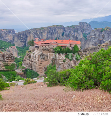 Stone monastery in the mountains. Kalabaka, Greece summer cloudy day in Meteora mountain valley. 90825686