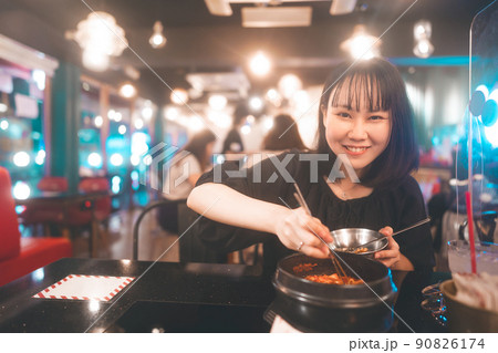 Portrait happy smile young adult asian woman eating ramyeon at Korean restaurant. Portrait happy smile young adult asian woman eating ramyeon at Korean restaurant. 90826174