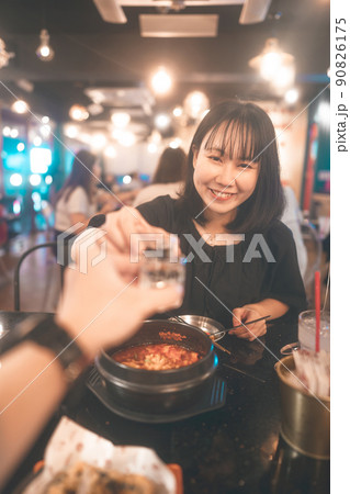 Portrait happy smile young adult asian woman cheer with soju at Korean restaurant. Portrait happy smile young adult asian woman cheer with soju at Korean restaurant. 90826175